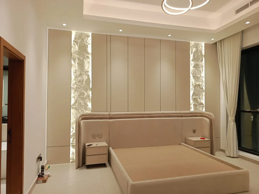 Custom upholstered bed with padded headboard and illuminated bedroom wall panels