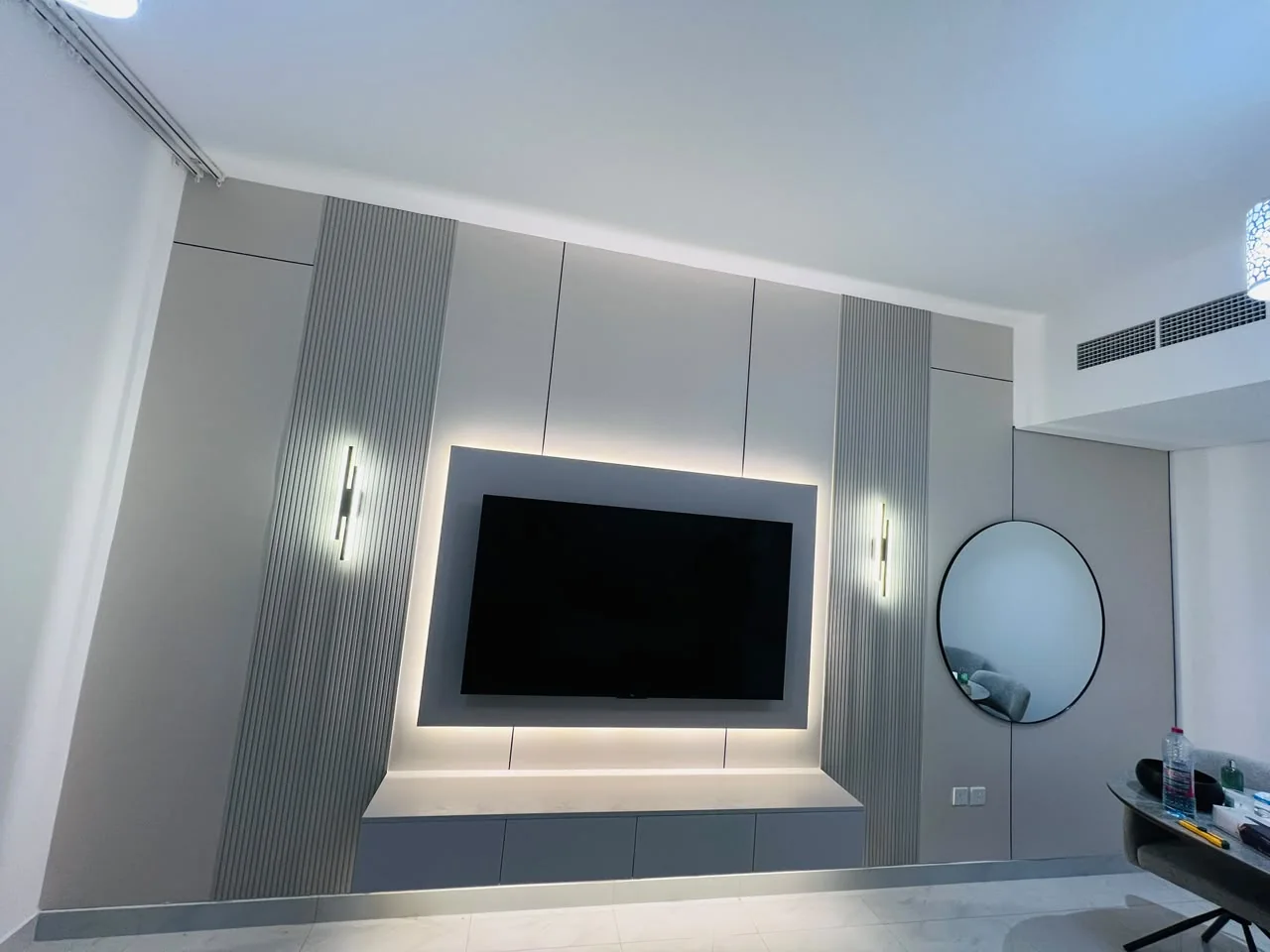 Custom TV media wall with grey panels, LED lighting and a floating console